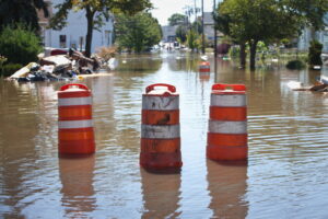 Orange blockade cones on a flooded street.